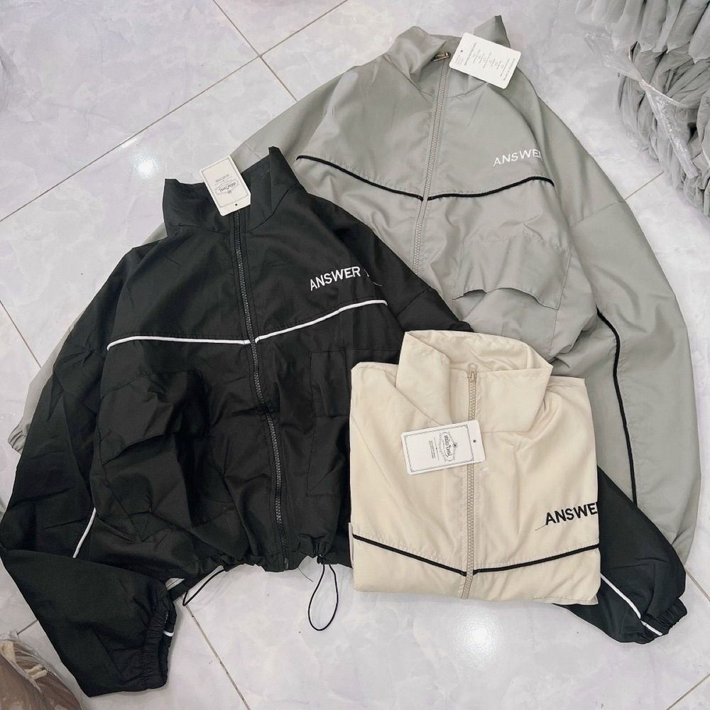 Áo khoác dù dáng lửng chạy mí viền,logo thêu, dây kéo phao.2 túi hộp trước ngực