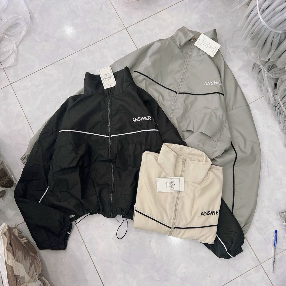 Áo khoác dù dáng lửng chạy mí viền,logo thêu, dây kéo phao.2 túi hộp trước ngực