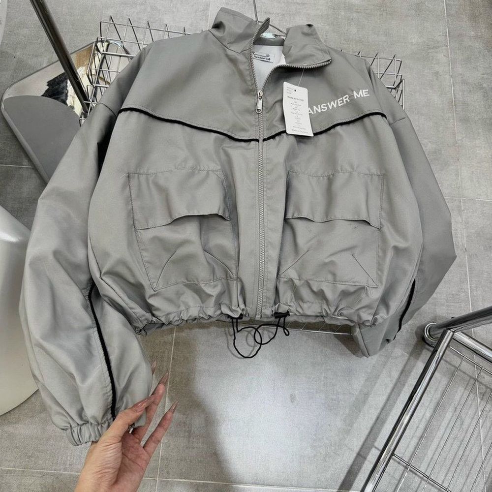 Áo khoác dù dáng lửng chạy mí viền,logo thêu ANSWER ME, dây kéo phao.2 túi hộp trước ngực