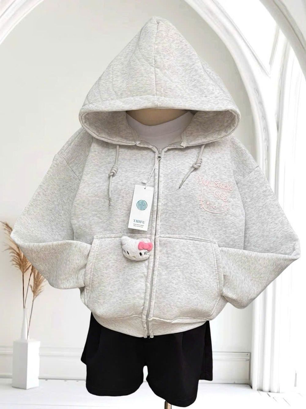 Áo khoác nữ Mon Studio logo in nổi có kèm charm mèo