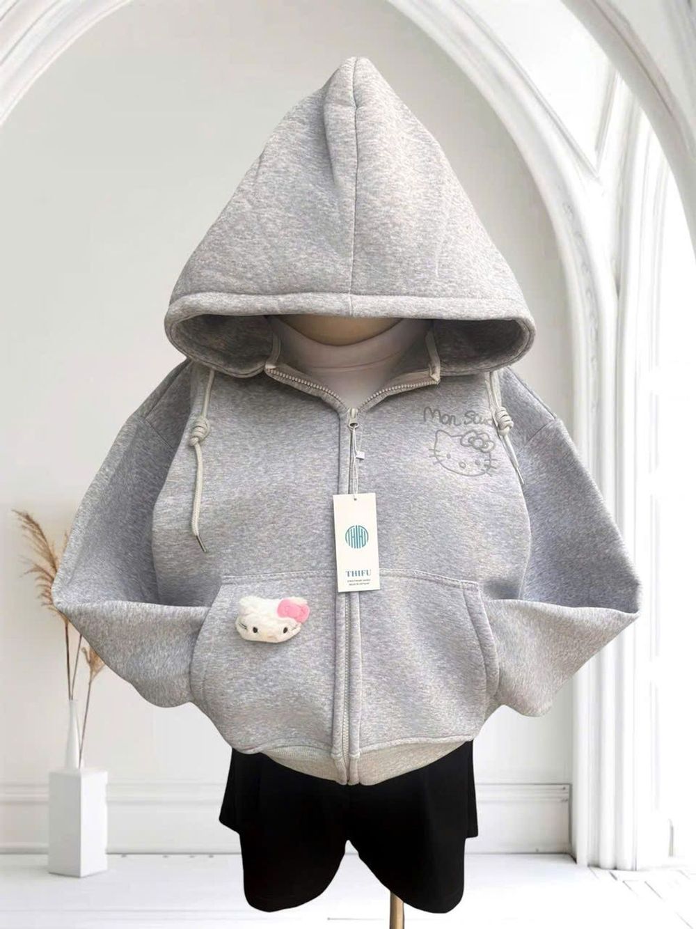 Áo khoác nữ Mon Studio logo in nổi có kèm charm mèo